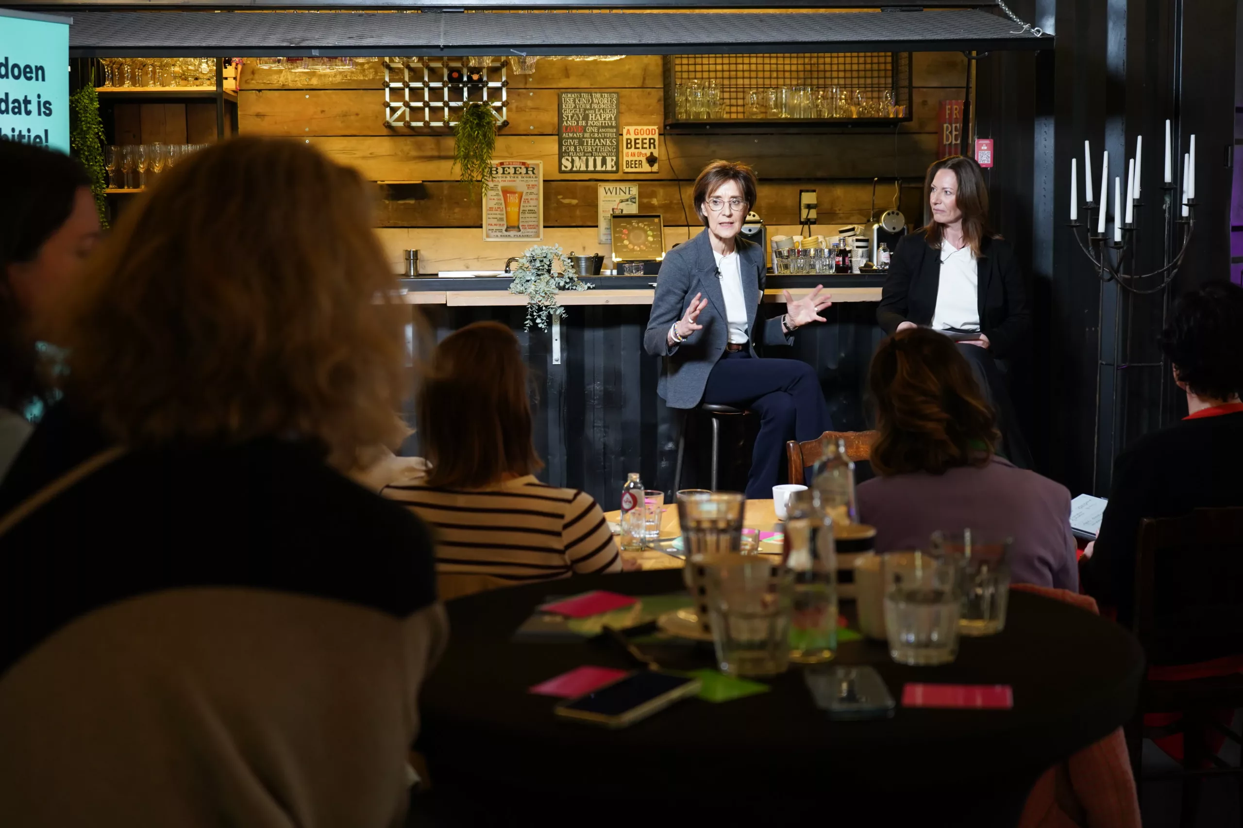 Debat over leiderschapstrainingen tijdens het CEOxHR-event van JDI, met het publiek aan tafels.