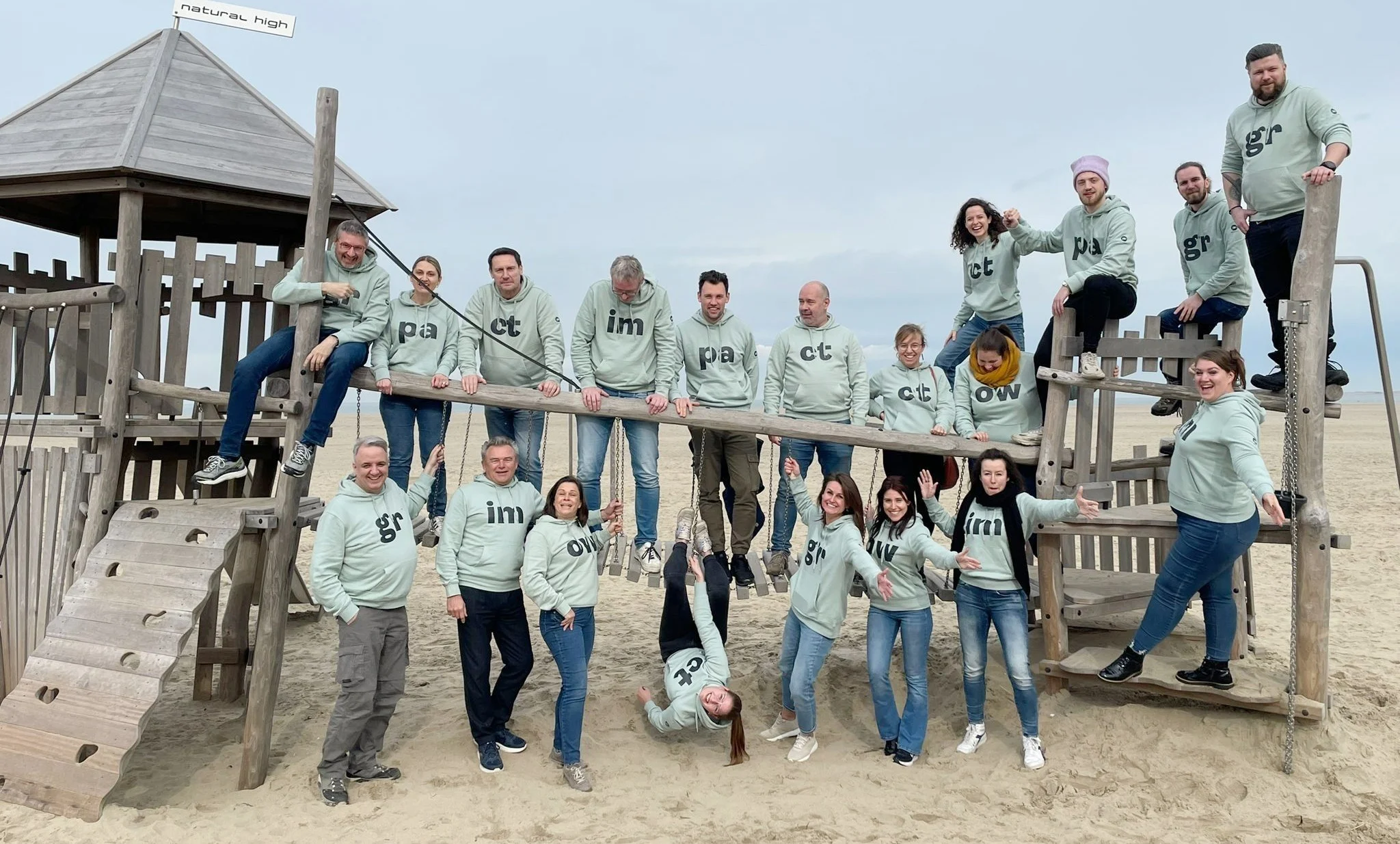 Het JDI-team in dezelfde truien op het strand.