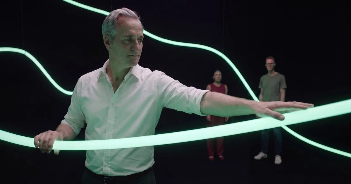 Een man trekt een lichtgevende groene buis recht
